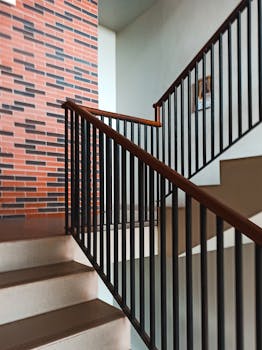 Contemporary staircase with a sleek railing and brick accent, perfect for modern interiors.