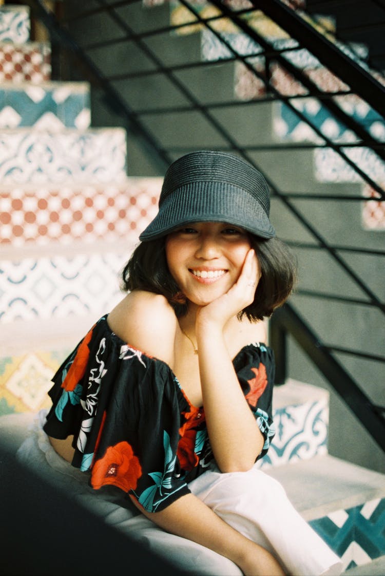 Young Woman In Black Cap And Off Shoulder Printed Blouse