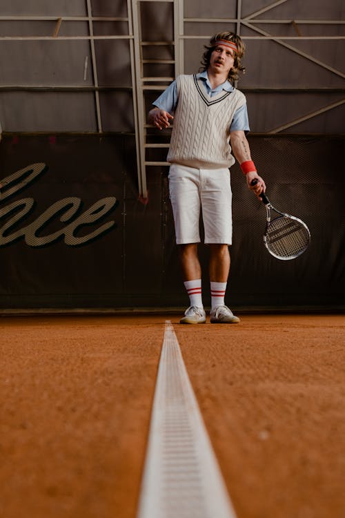 Man Holding a Tennis Racket in the Clay Court 