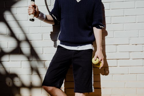 Man Holding Racket and Two Tennis Balls