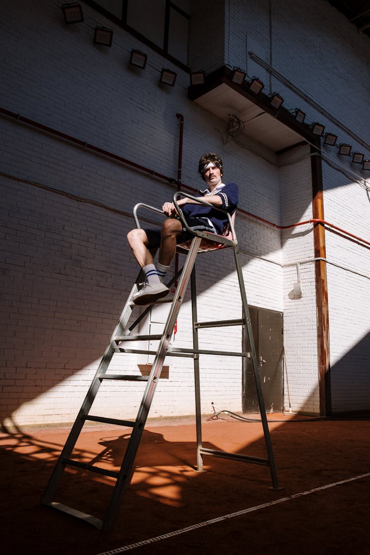 Low-Angle Shot Of A Man Sitting On An Umpire Chair