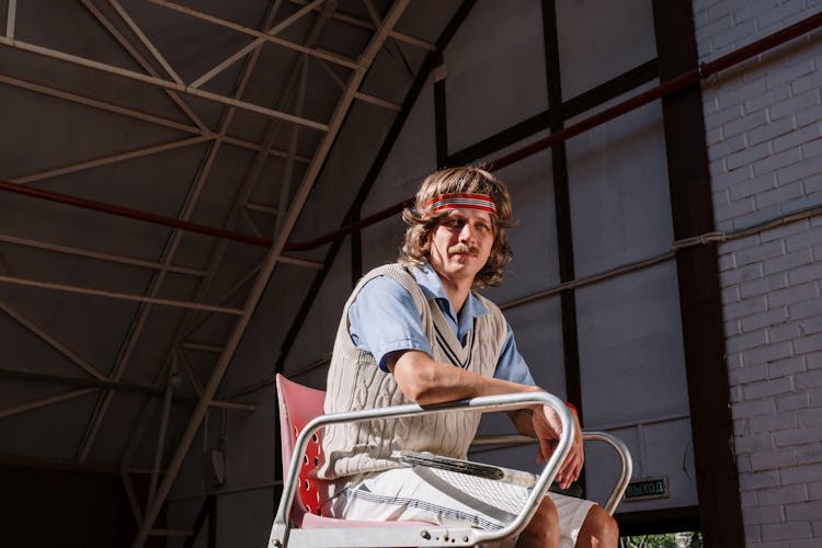 Photo Of A Man In A Sweater Vest Wearing A Red Sweatband