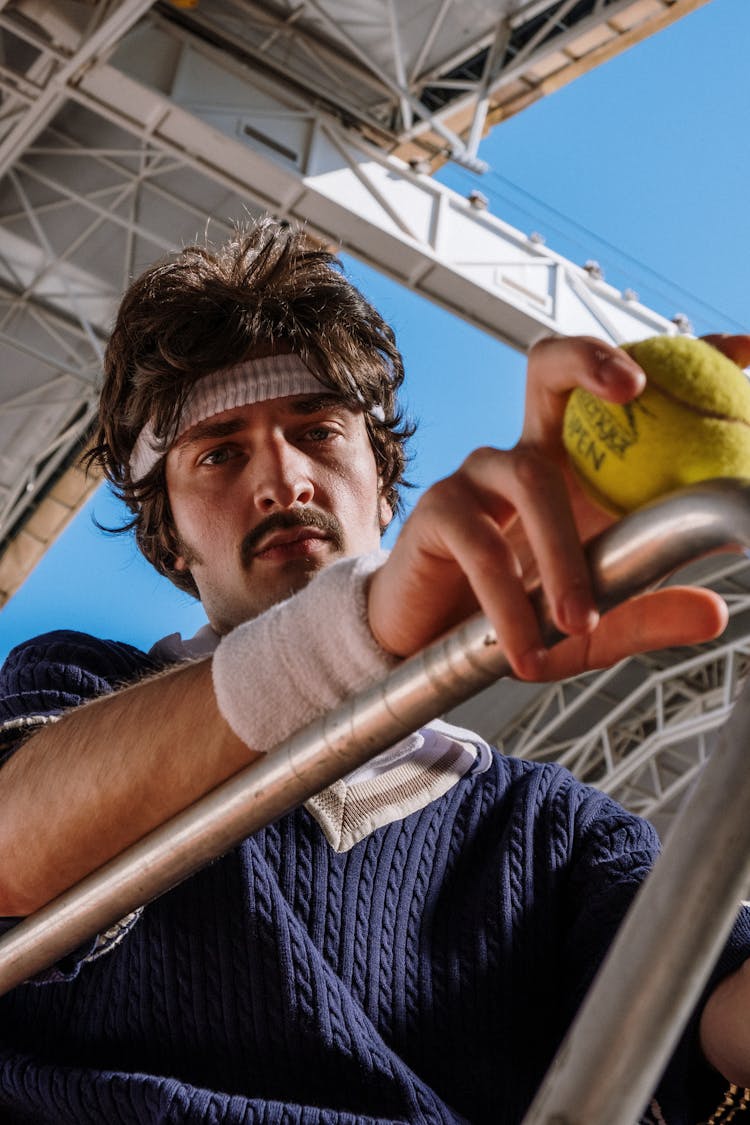 Portrait Of A Man With A White Wristband Holding A Tennis Ball