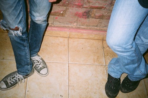 Two Person Wearing Blue Jeans and Lace-up Shoes