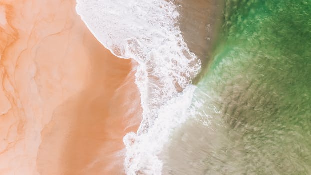 Stunning aerial view of a tropical beach in Kijal, Malaysia with waves rolling onto sandy shores.