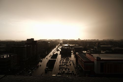 Free Drone view of modern city district with typical houses and asphalt road with vehicles in sunset Stock Photo