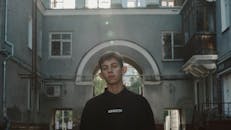 Man standing near gray building