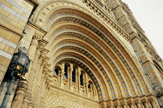 Intricate facade of the Natural History Museum in London showcasing arched windows and detailed stonework.