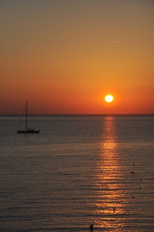 Silhouette of a Boat on a Sea during Sunset