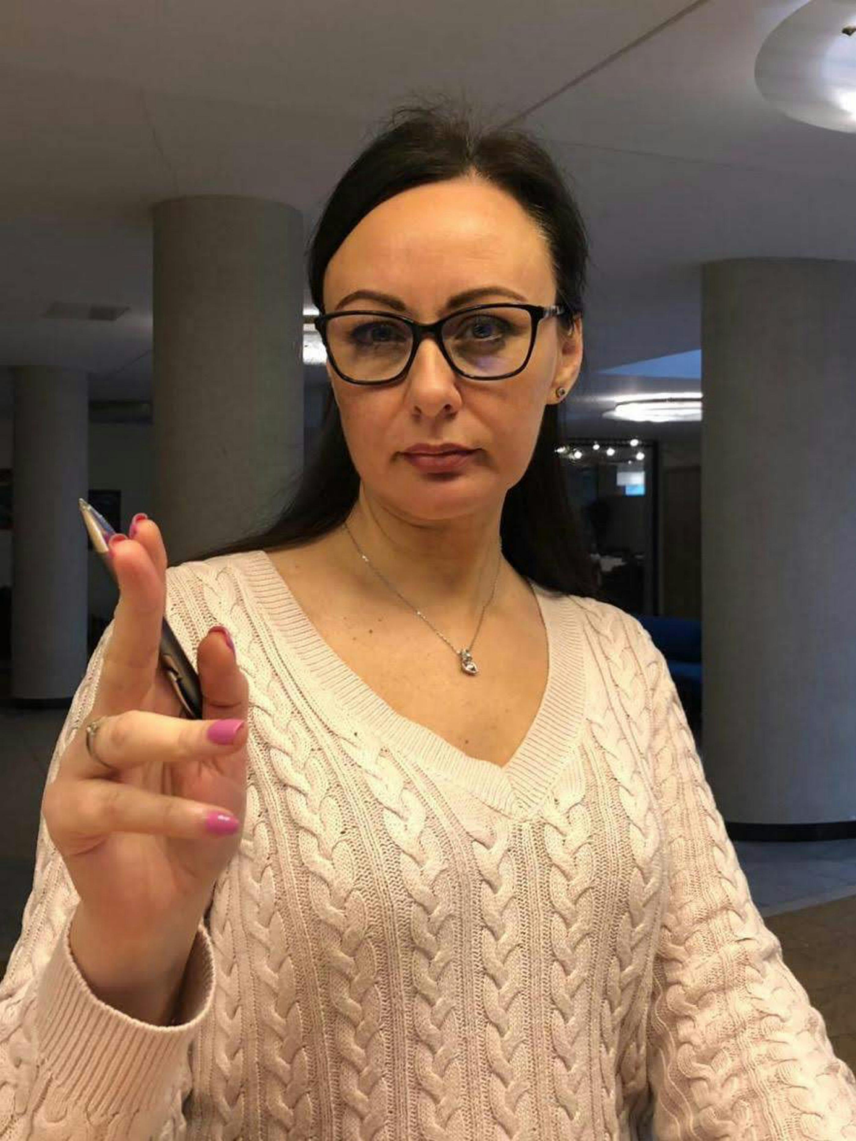 A dog lying contentedly in the grass beside a campsite with mountains visible in the distance