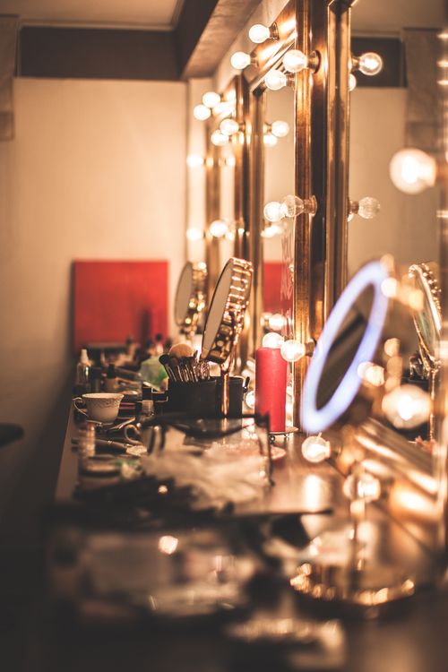 Free A stylishly lit makeup vanity showcasing elegant lights and cosmetics in a glamorous setting. Stock Photo