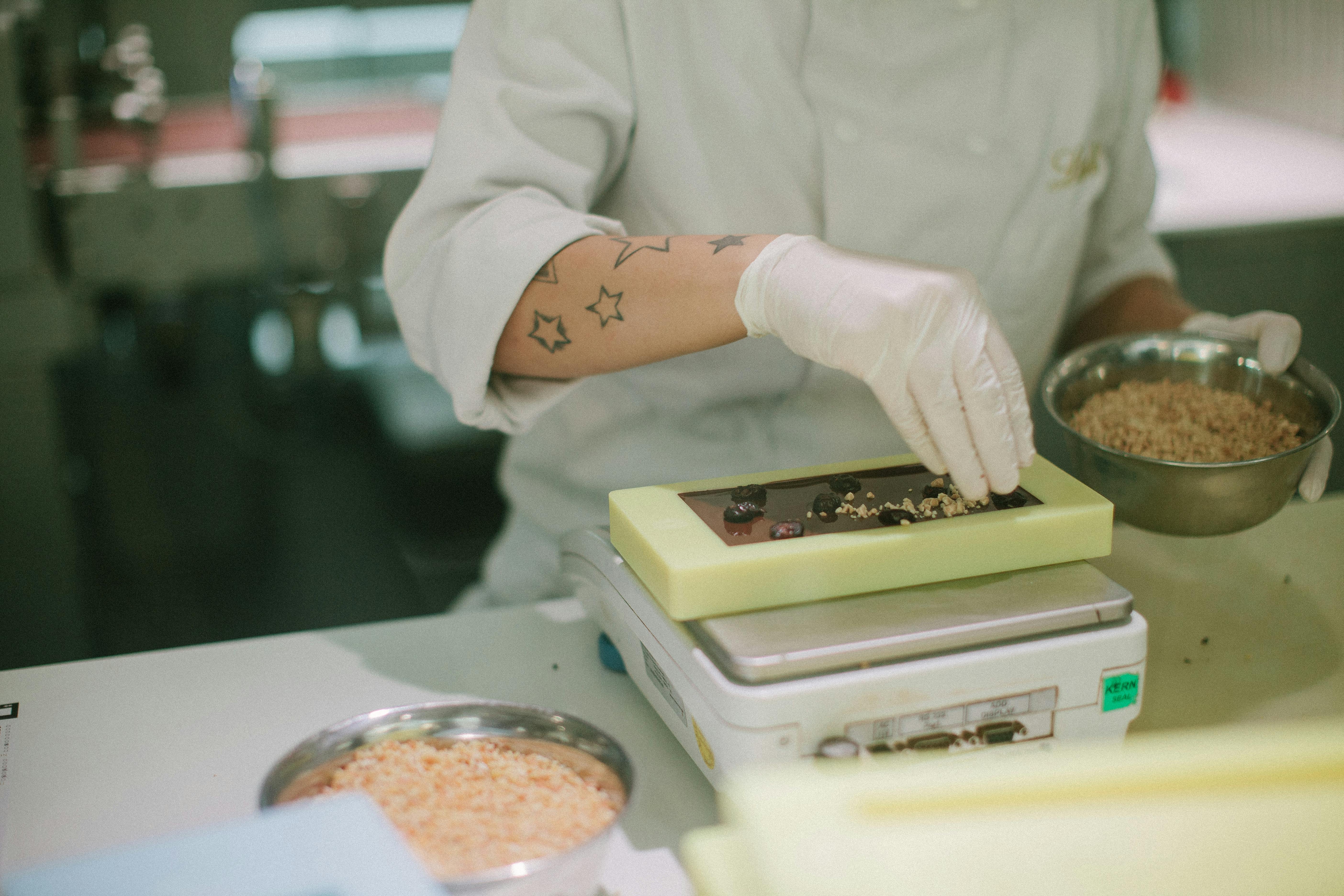 Person in Gloves Making Chocolate at Factory