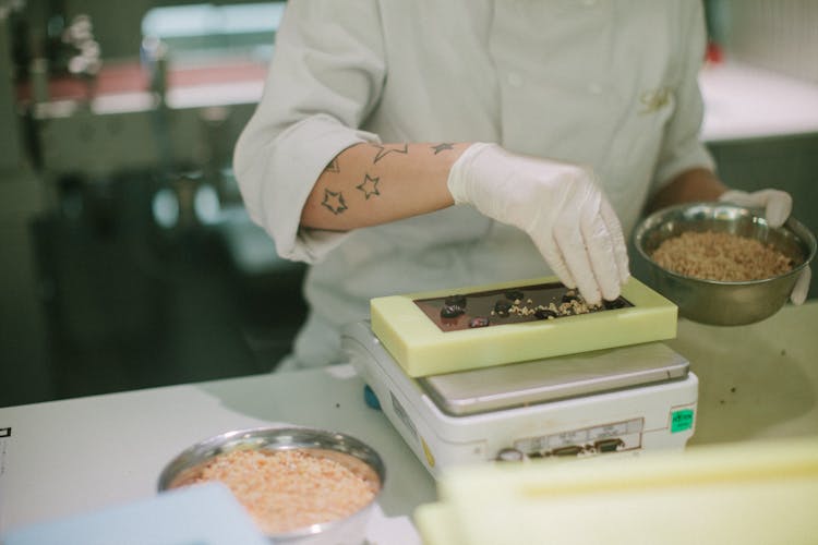 Person In Gloves Making Chocolate At Factory