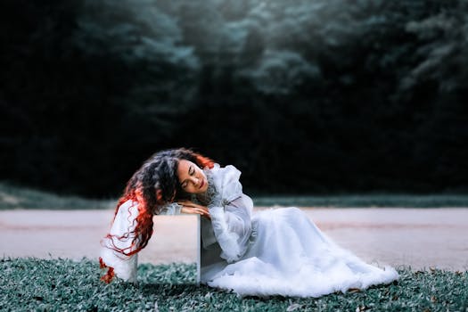 一位身穿优雅白色连衣裙的女子躺在户外草地上，散发着宁静而艺术的气息