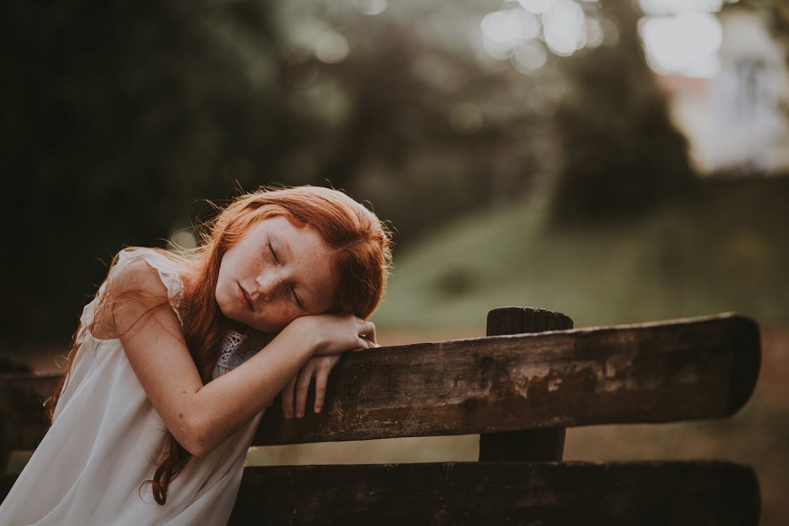 Free Girl Leaning Her Head on Her Hand While Closing Her Eyes Stock Photo