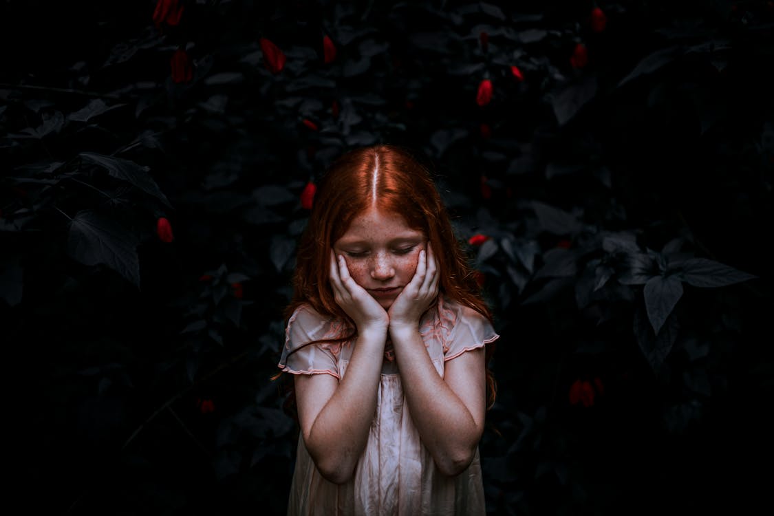 Red-haired Girl Standing Near Plant