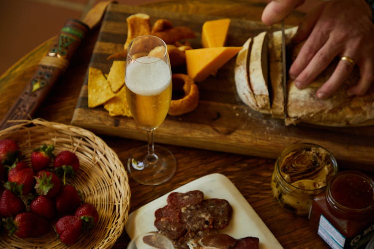 Man Slicing Bread On A Wooden Board