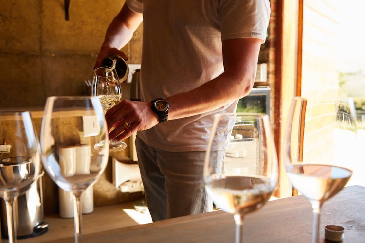 An Image Of A Person Pouring A Drink Of A Glass Wine