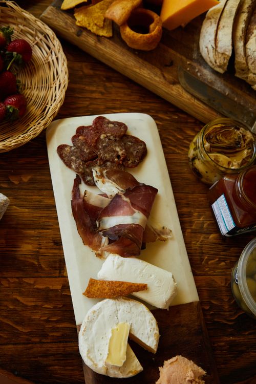 Free Delicious gourmet charcuterie board with a variety of cheeses and meats, perfect for a savory snack. Stock Photo