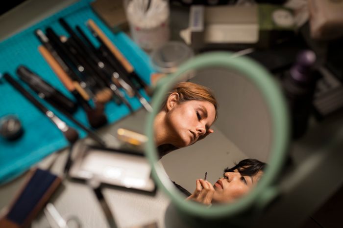 A tutor working with a student at a mirror