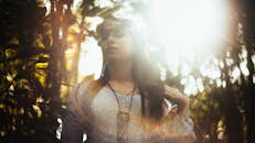 森林里，一位宁静的女人头戴花卉王冠，被阳光照亮，散发出一种神秘的氛围