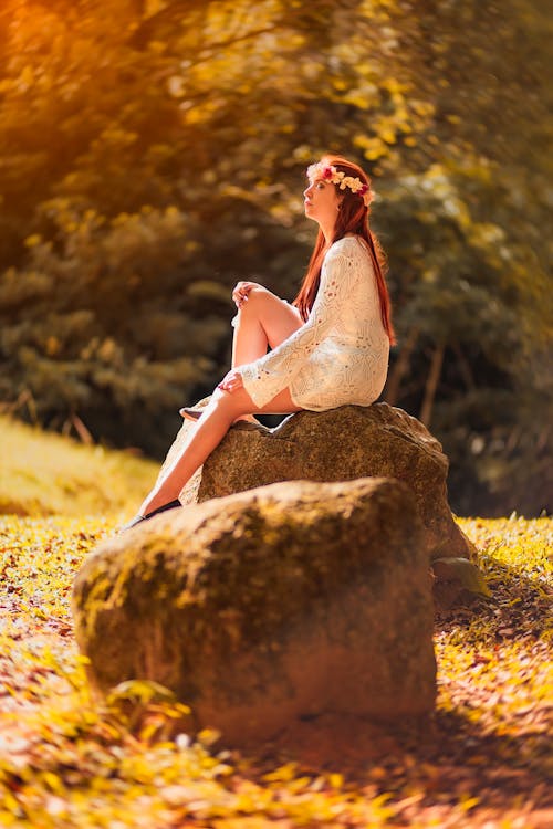 女人坐在棕色的石頭上