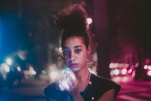 夜色中，一位卷发的年轻女子举着灯光，营造出梦幻般的氛围