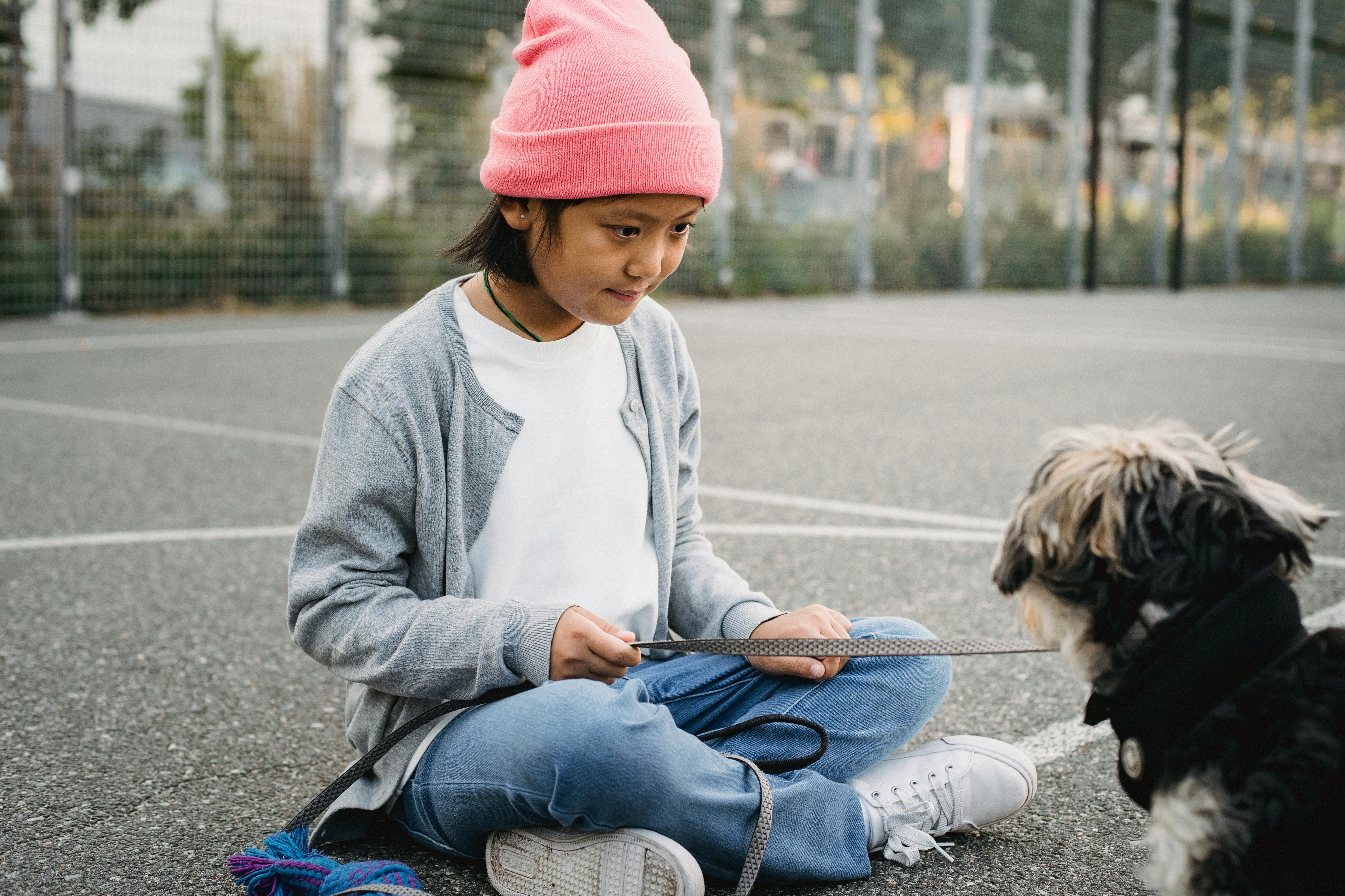 asian boy with purebred dog on urban sports ground