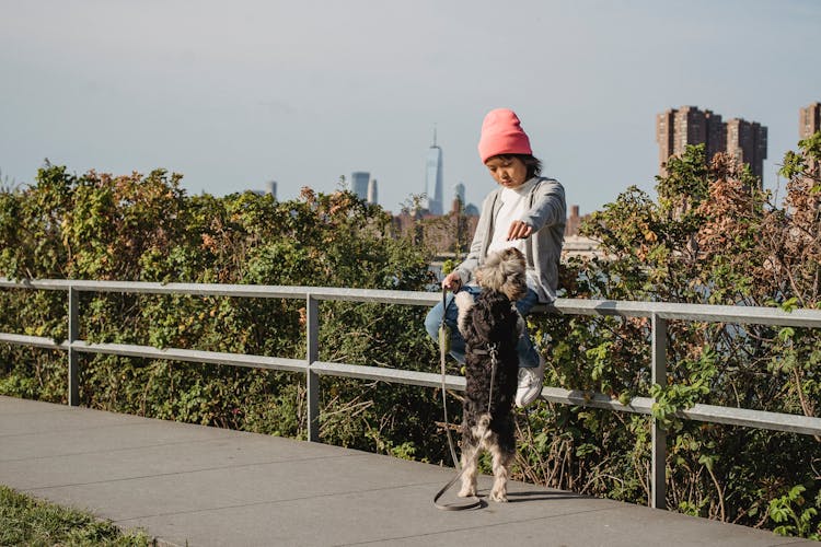 Asian Boy With Dog In Park