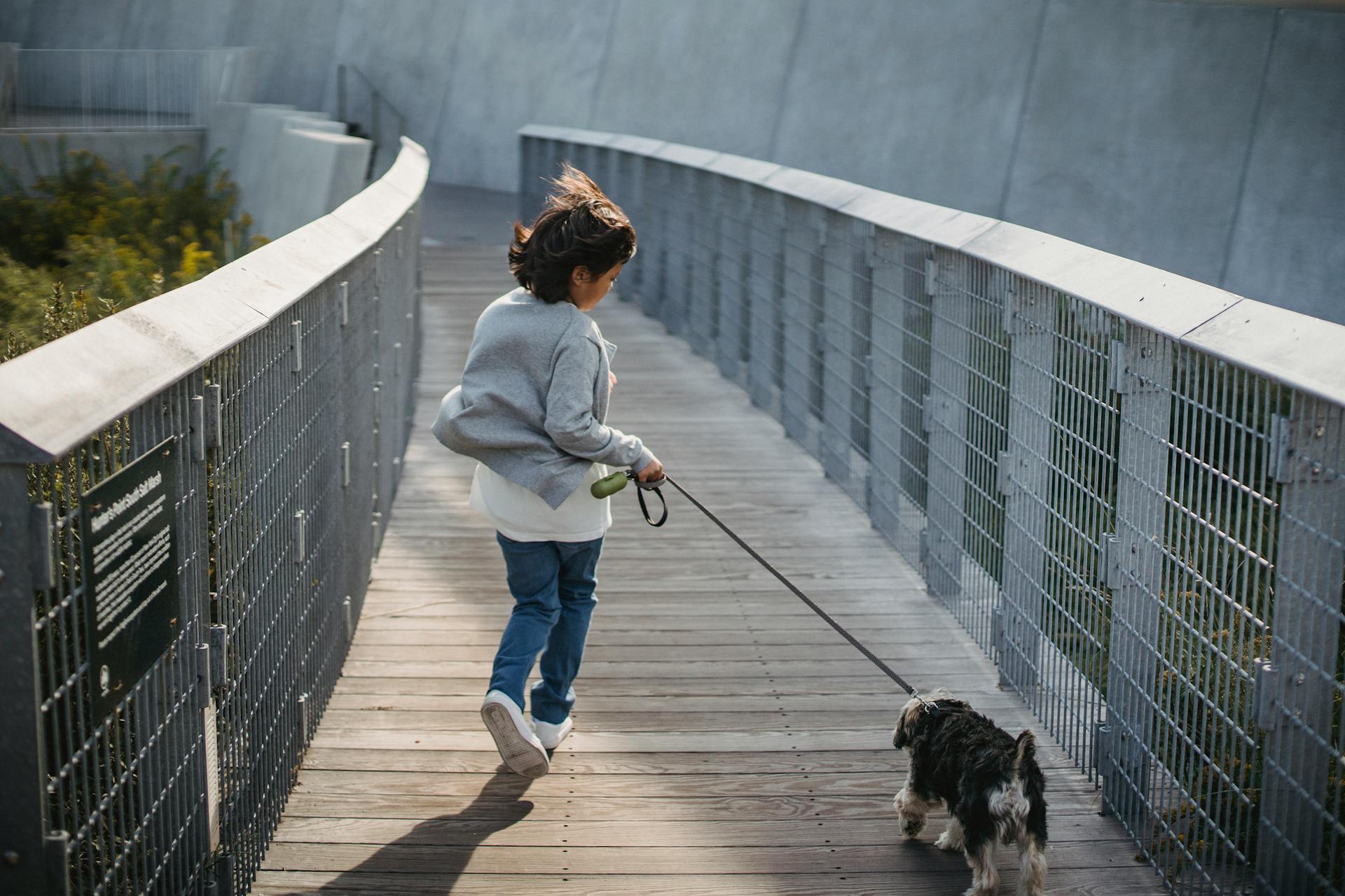 Anonymous kid running with dog on leash