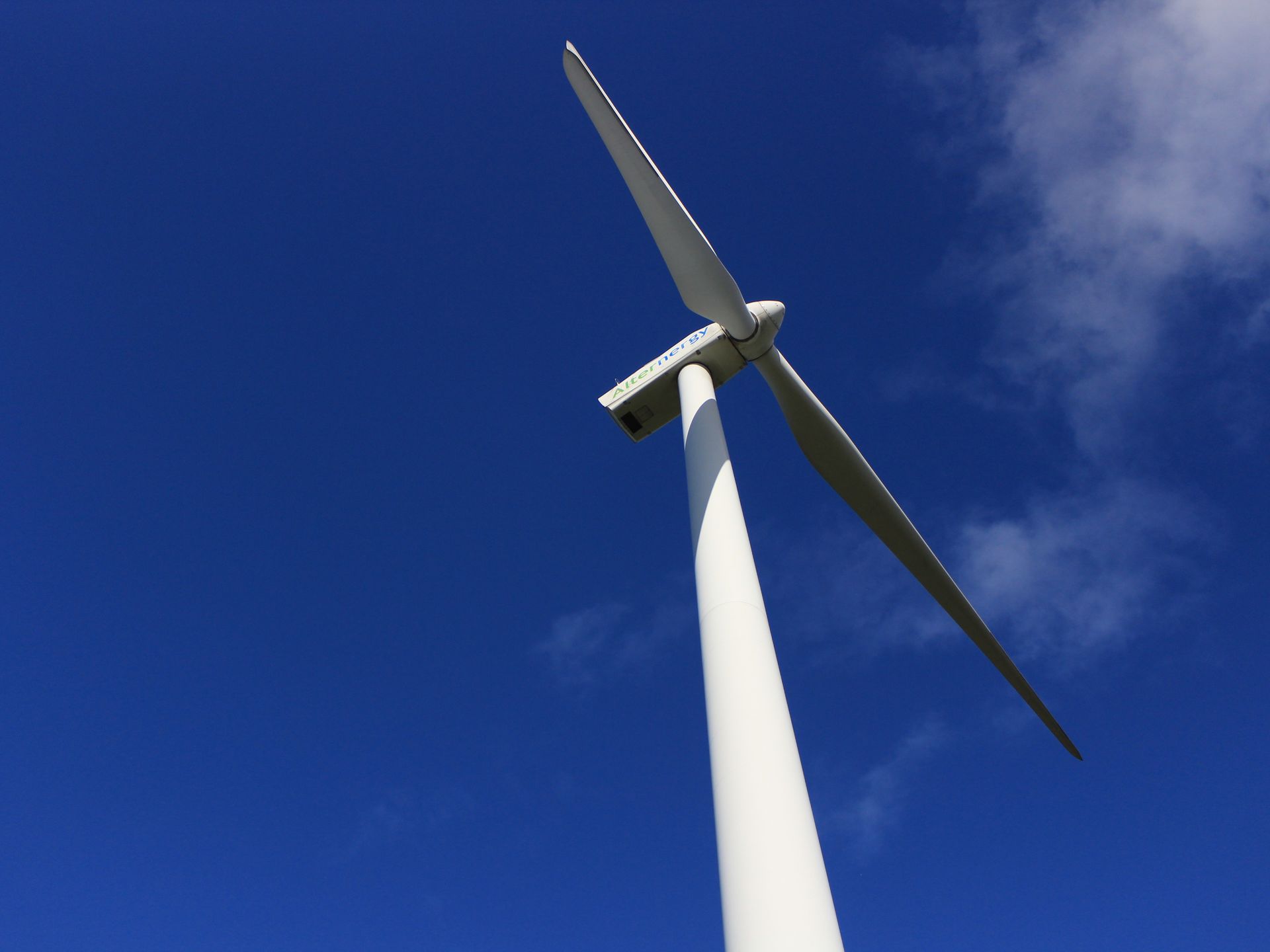 A majestic wind turbine towering against a bright blue sky, showcasing renewable energy.