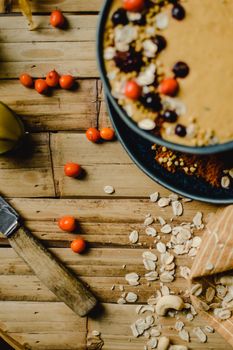Top-down view of a healthy breakfast bowl with fresh berries and oats on a wooden table for a nutritious start.