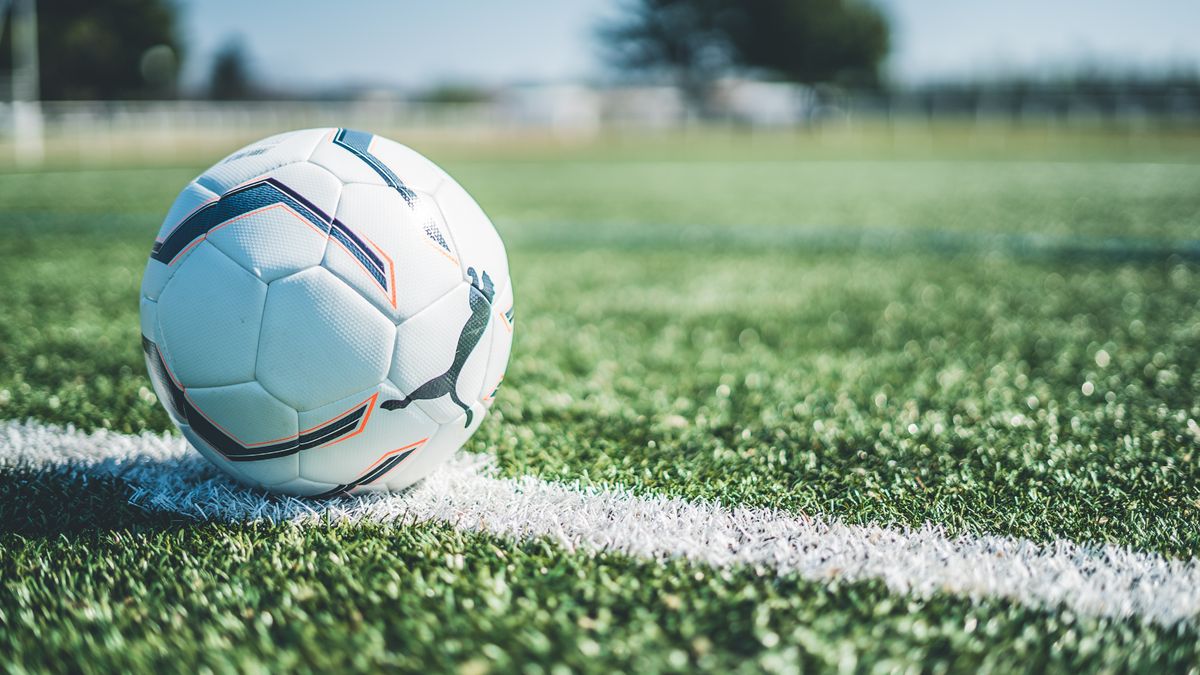 Yeşil çim sahada futbol topu ve beyaz çizgiler