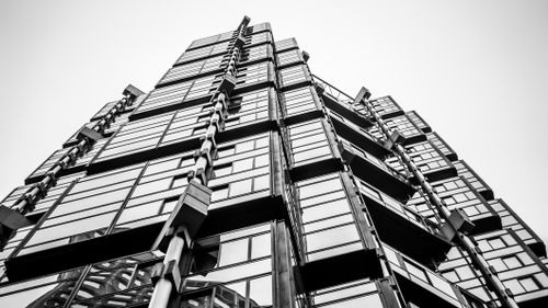 Free Black and white photo capturing a modern highrise with distinctive glass panel architecture. Stock Photo