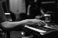 Crop pianist adjusting control panel of synthesizer during rehearsal