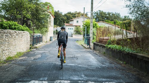 Person in Black Long Sleeve Shirt Riding Bicycle on the Road