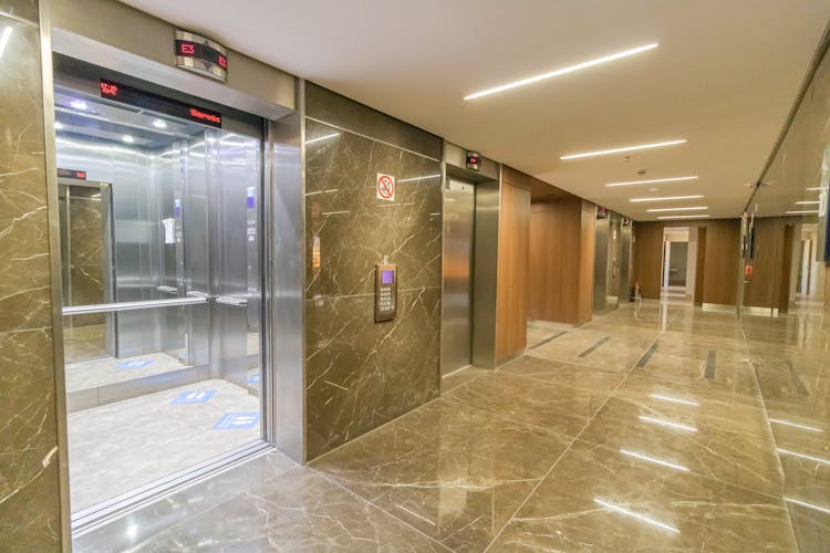 Corridor Of Modern Building With Opened Elevator Doors