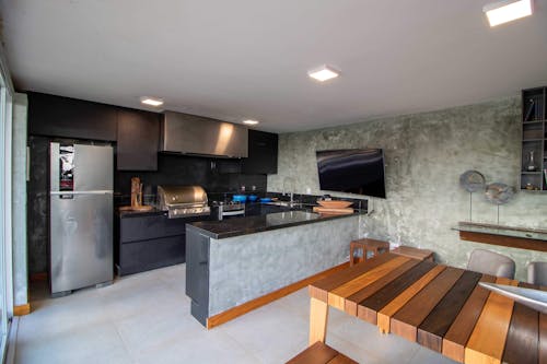 Stylish interior of kitchen with TV set hanging on wall