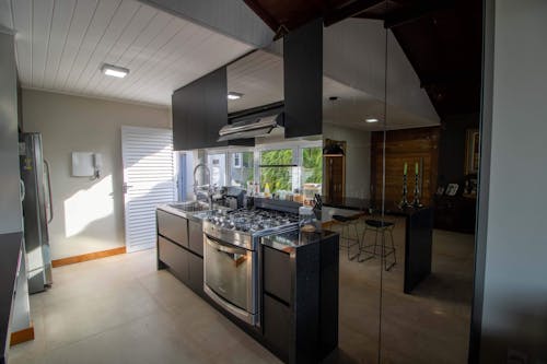 Free Interior of empty kitchen in contemporary apartment with large mirror in bright daylight Stock Photo