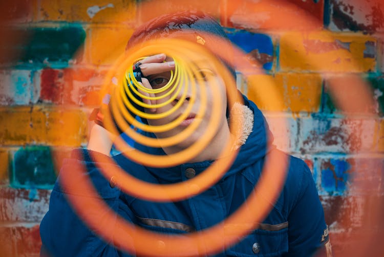 A Boy Looking Through A Plastic Object
