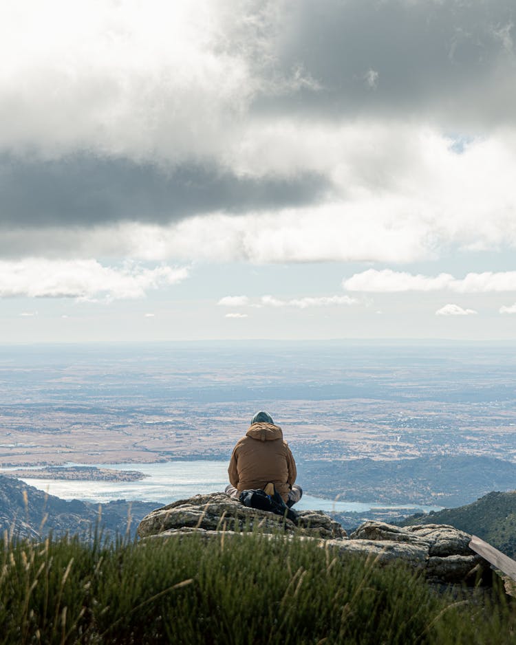 Person Sitting On Rocks Overlooking Landscape