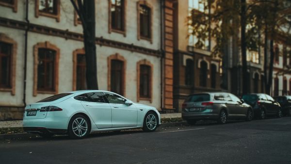 White sedan company car parked on a city street