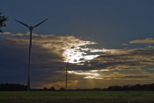 Wind Turbines on Green Grass Field Under Cloudy Sky