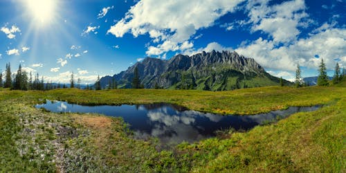 Mountain on Green Grass Near Body of Water