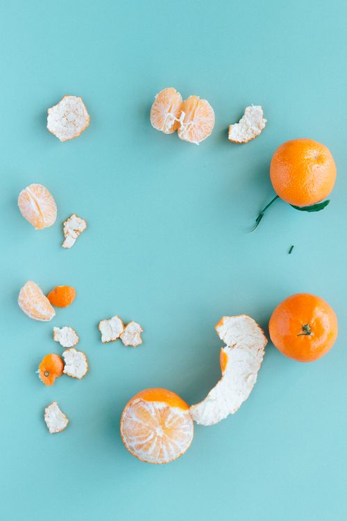 Free Top view of fresh mandarin oranges and peels on a vibrant blue background. Stock Photo