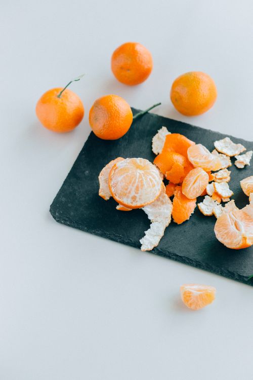 Free Peeled mandarins and citrus fruits on a slate board, perfect for food content. Stock Photo