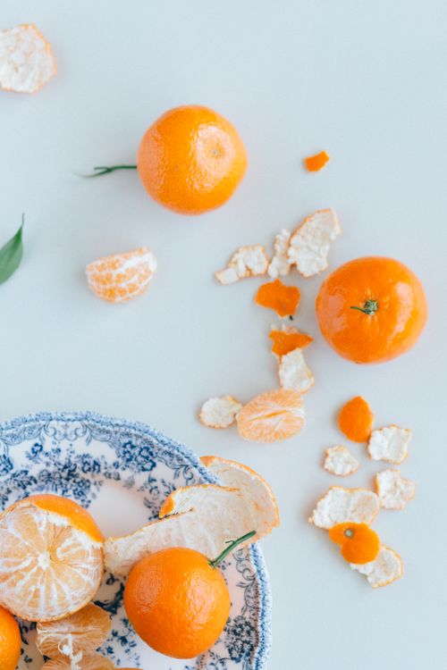 Free Top-down view of ripe mandarin oranges and peels on a white surface for a fresh and vibrant look. Stock Photo