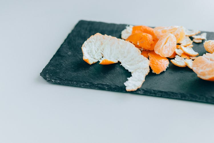 Orange Peel And Pieces Of Mandarin On A Chopping Board