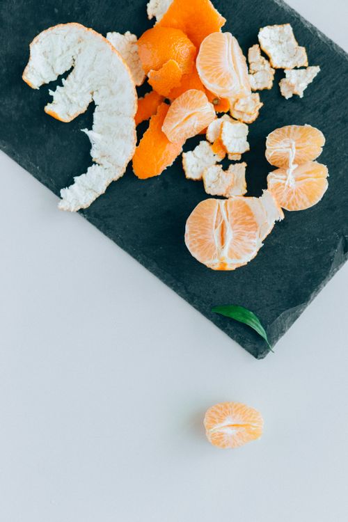 Free Peeled mandarin pieces and peel on a slate board for a fresh, vibrant look. Stock Photo