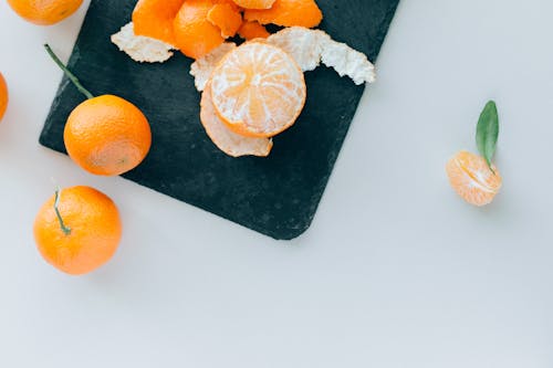 Бесплатное стоковое фото с flat lay, апельсин, белый фон